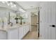 Bathroom featuring double sinks, a large mirror, and access to a bedroom at 26052 Salonika Ln, Punta Gorda, FL 33983