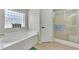 Relaxing bathroom with a soaking tub, walk-in shower, and a bright window at 26052 Salonika Ln, Punta Gorda, FL 33983