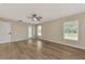 Light-filled bedroom with wood flooring, a ceiling fan, and glass door for outside access at 26052 Salonika Ln, Punta Gorda, FL 33983
