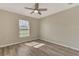 Bedroom features wood-look flooring, ceiling fan, and a large window for natural light at 26052 Salonika Ln, Punta Gorda, FL 33983