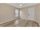A cozy bedroom with wood floors, a ceiling fan, and a window for natural light at 26052 Salonika Ln, Punta Gorda, FL 33983