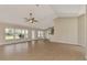 Open-concept living area with sliding glass doors and expansive tile flooring at 26052 Salonika Ln, Punta Gorda, FL 33983