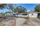 Charming single-story home with a spacious driveway and classic white exterior nestled under mature trees at 3365 7Th St, Sarasota, FL 34237