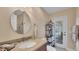 Well-lit bathroom featuring a large round mirror, modern fixtures, and access to outdoor patio at 3445 Highlands Bridge Rd, Sarasota, FL 34235