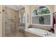 Bright bathroom featuring a glass shower, soaking tub, and decorative fixtures at 3445 Highlands Bridge Rd, Sarasota, FL 34235