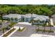 An aerial view shows the modern clubhouse and ample parking, surrounded by lush landscaping and trees at 3445 Highlands Bridge Rd, Sarasota, FL 34235