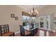 Dining area featuring a modern glass table, chandelier, and outdoor views at 3445 Highlands Bridge Rd, Sarasota, FL 34235