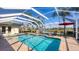 Private screened-in pool with spa, lounge chairs, umbrella table, and water view at 3445 Highlands Bridge Rd, Sarasota, FL 34235