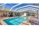 Screened-in pool and spa with an outdoor living area, lounge chairs, and lush landscaping at 3445 Highlands Bridge Rd, Sarasota, FL 34235