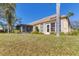 Exterior view of the home with an expansive backyard, lush lawn, and mature landscaping at 3522 57Th Avenue W Cir, Bradenton, FL 34210