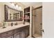 Beautiful bathroom featuring dark wood cabinets with granite countertop, stylish fixtures and tile shower at 3522 57Th Avenue W Cir, Bradenton, FL 34210
