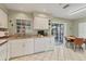 Well-lit kitchen with white cabinets, open access to the breakfast nook, and stylish tile flooring at 3522 57Th Avenue W Cir, Bradenton, FL 34210