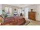 Comfortable main bedroom with a ceiling fan, windows with decorative curtains and ensuite bathroom at 3522 57Th Avenue W Cir, Bradenton, FL 34210