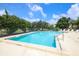 Sparkling community pool with clear blue water, surrounded by lush landscaping and plenty of lounge chairs at 3522 57Th Avenue W Cir, Bradenton, FL 34210