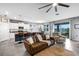 Open-concept living room with leather furniture, ceiling fan, and access to an outdoor patio at 4034 Mossy Limb Ct, Palmetto, FL 34221