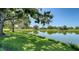 Lush backyard with mature trees and serene water view, providing a peaceful retreat at 4060 Penshurst Park, Sarasota, FL 34235