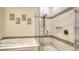 Bathroom featuring soaking tub and frameless glass shower with niche, and bronze hardware at 4060 Penshurst Park, Sarasota, FL 34235