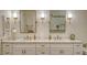 Bathroom with double sink vanity, with ample drawer and cabinet space, bronze hardware and custom lighting at 4060 Penshurst Park, Sarasota, FL 34235