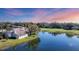 Beautiful home exterior with golf course view, lush trees, and a serene lake at sunset at 4060 Penshurst Park, Sarasota, FL 34235