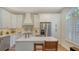 Bright kitchen with white cabinets, stainless steel appliances, and a cozy breakfast bar seating area at 4060 Penshurst Park, Sarasota, FL 34235