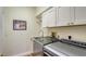 Functional laundry room featuring modern washer and dryer with overhead cabinets at 4060 Penshurst Park, Sarasota, FL 34235