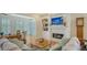 Cozy living room with fireplace, built ins and views of the lush garden and lake at 4060 Penshurst Park, Sarasota, FL 34235