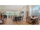 Bright living room with fireplace, grand piano, and views overlooking a serene lake at 4060 Penshurst Park, Sarasota, FL 34235