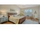 Comfortable main bedroom shows a large window with shutters, neutral walls, and wood-look flooring at 4060 Penshurst Park, Sarasota, FL 34235