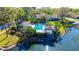 Aerial view of a pool, lanai, and lake surrounded by lush landscaping, creating a private oasis at 4060 Penshurst Park, Sarasota, FL 34235