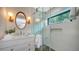 Modern bathroom featuring a glass-enclosed shower, stylish vanity, and a round mirror with decorative lighting at 422 Burns Ct, Sarasota, FL 34236