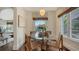 Sunlit breakfast nook featuring a glass table with wooden base and natural woven chairs beneath a pendant light at 422 Burns Ct, Sarasota, FL 34236