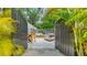 Tranquil gated patio showcasing outdoor seating, a dining set, and lush tropical foliage for private relaxation at 422 Burns Ct, Sarasota, FL 34236