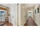Hallway leading to an office space featuring hardwood floors, white trim, an arched doorway, and a window at 422 Burns Ct, Sarasota, FL 34236