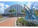 Stunning exterior view of a modern hotel with palm trees and artistic water sculpture at 422 Burns Ct, Sarasota, FL 34236