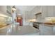 Well-lit kitchen featuring white cabinets, stainless steel appliances, and light countertops with a view of the red back door at 422 Burns Ct, Sarasota, FL 34236