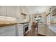 Charming kitchen with stainless steel range, white cabinets, tile backsplash, and breakfast nook with warm wood floors at 422 Burns Ct, Sarasota, FL 34236