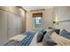 Inviting bedroom featuring a king bed with blue bedding, large closets, a window with woven shade, and wood floors at 422 Burns Ct, Sarasota, FL 34236