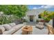 Charming outdoor patio with comfortable lounge seating, a wooden coffee table, and manicured landscaping at 422 Burns Ct, Sarasota, FL 34236