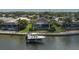 Aerial view of waterfront home with boat dock, lift, screened pool, landscaping, and waterway access at 5040 Lake Overlook Ave, Bradenton, FL 34208