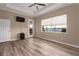 Bedroom with a ceiling fan, wood floor and view of the water, a door leading to the patio, and a television on the wall at 5040 Lake Overlook Ave, Bradenton, FL 34208