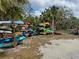 Organized canoe and kayak storage racks with colorful boats amid lush greenery and sunny skies at 5040 Lake Overlook Ave, Bradenton, FL 34208