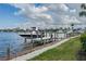 Dock overlooking calm waters, a boat, and surrounding residences on a sunny day with cloudscape sky at 5040 Lake Overlook Ave, Bradenton, FL 34208