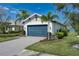 View of the garage with an attractive blue door, beautiful landscaping, and a brick-paved drive at 5040 Lake Overlook Ave, Bradenton, FL 34208