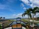 Scenic view of community waterway with dock, bench, and palm trees against a beautiful blue sky at 5040 Lake Overlook Ave, Bradenton, FL 34208