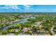 An aerial view showcases waterfront property with surrounding lush greenery at 5135 Riverwood Ave, Sarasota, FL 34231