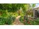 Lush backyard garden featuring a stone path, decorative water fountain, and screened patio area at 5135 Riverwood Ave, Sarasota, FL 34231