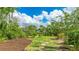 Landscaped backyard featuring lush greenery, stepping stones, and mulched garden beds with beautiful views of the canal at 5135 Riverwood Ave, Sarasota, FL 34231