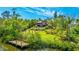 Lush backyard featuring a dock, large lawn, mature trees, and a large in-ground pool surrounded by greenery at 5135 Riverwood Ave, Sarasota, FL 34231