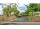 Gated driveway leading to a spacious three-car garage surrounded by mature trees and landscaping at 5135 Riverwood Ave, Sarasota, FL 34231