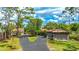 A long, curved driveway leads to the garage of a single-Gathering home at 5135 Riverwood Ave, Sarasota, FL 34231